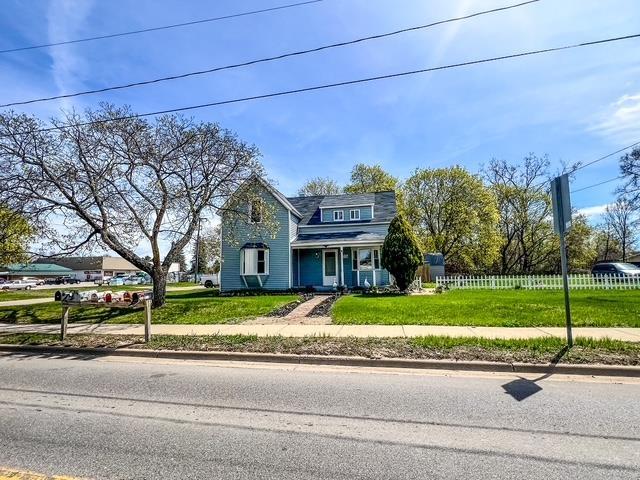 traditional home featuring fence and a front lawn