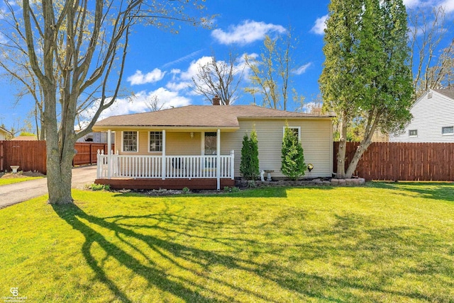 ranch-style home featuring a porch, a chimney, a front yard, fence, and a shingled roof