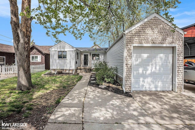 ranch-style house with concrete driveway, fence, and a garage