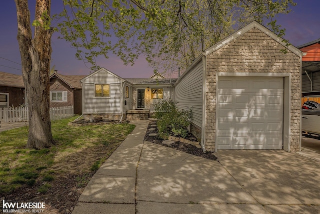 ranch-style home featuring concrete driveway, fence, and a garage