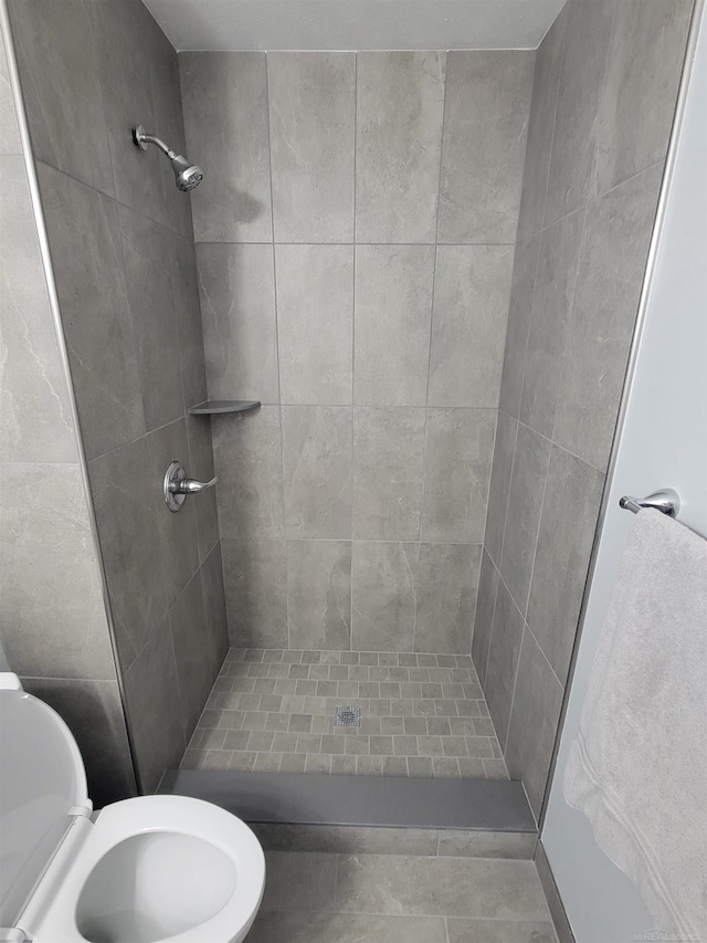 bathroom featuring toilet and a shower stall