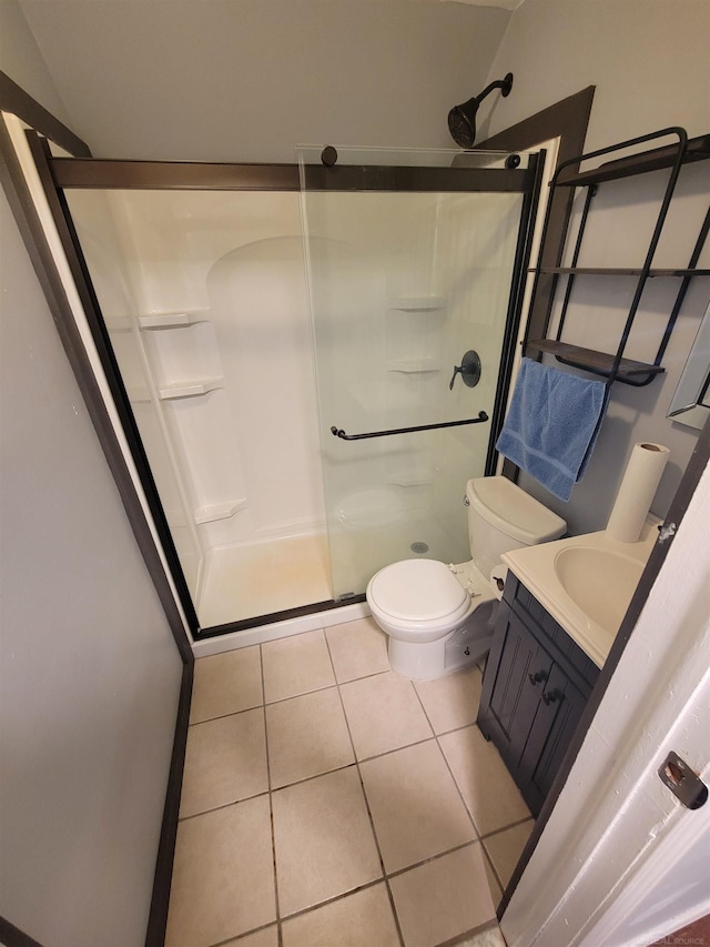 full bath with tile patterned flooring, a stall shower, toilet, and vanity