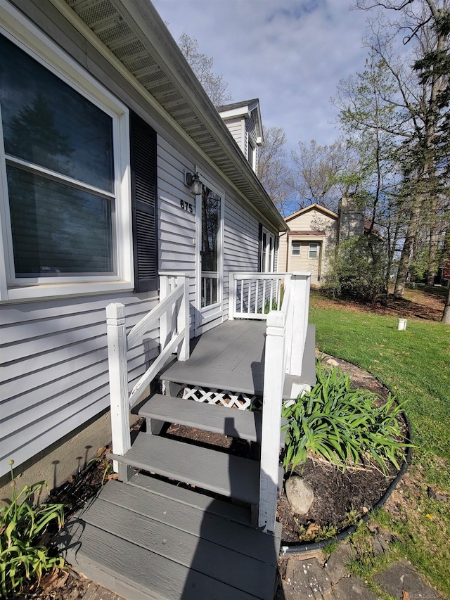 doorway to property with a yard and a deck