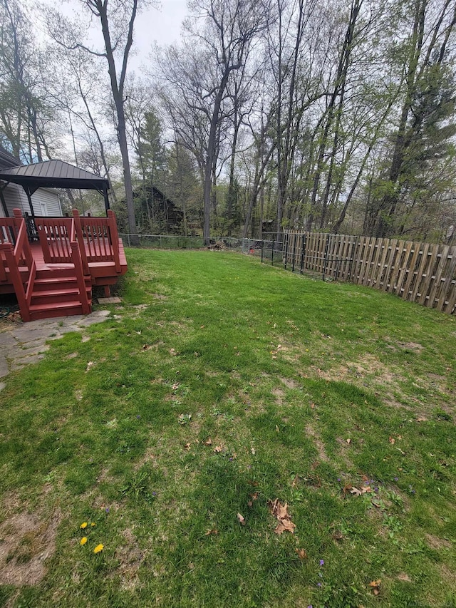 view of yard featuring a gazebo, a wooden deck, and a fenced backyard