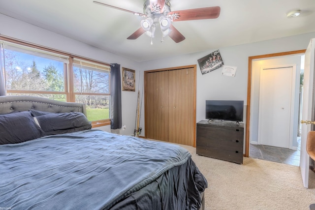 bedroom with ceiling fan, carpet, and a closet