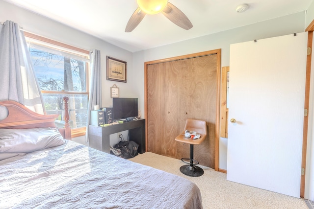 carpeted bedroom featuring ceiling fan and a closet