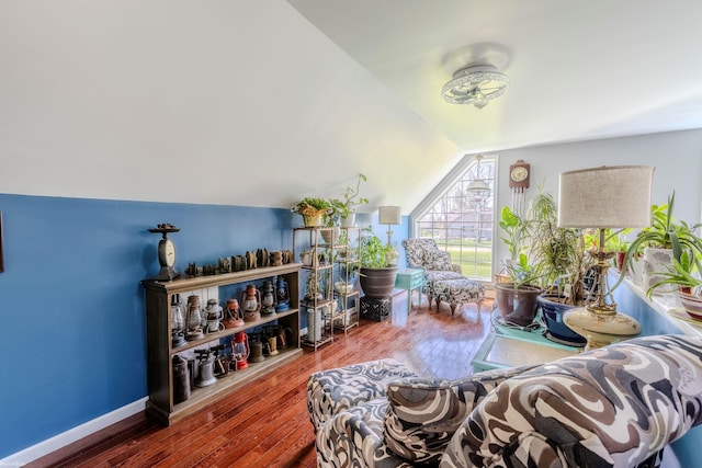 interior space with baseboards, vaulted ceiling, and hardwood / wood-style flooring