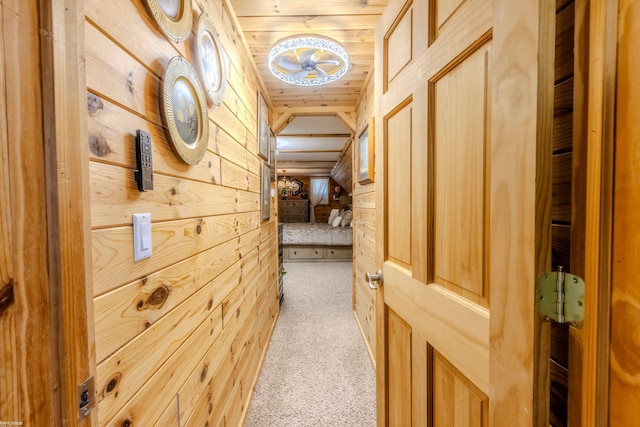 hallway with carpet floors, wood walls, and wooden ceiling