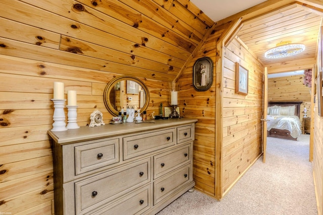 hall with wood ceiling, lofted ceiling, wooden walls, and light carpet