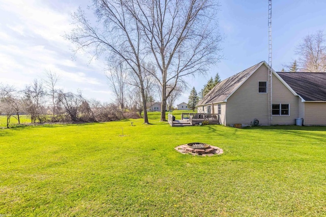 view of yard with a wooden deck and a fire pit