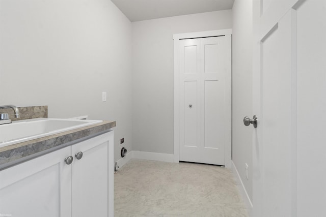 laundry area featuring cabinet space, hookup for an electric dryer, a sink, and baseboards