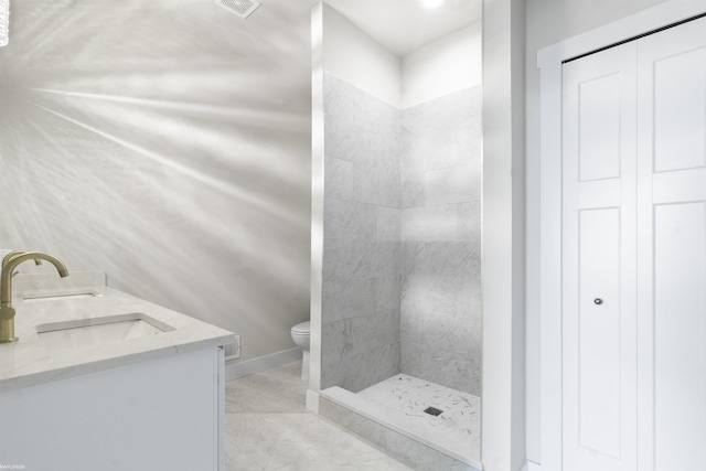 full bathroom featuring a sink, a shower stall, toilet, and double vanity