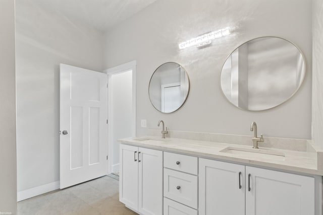 full bathroom with a sink, baseboards, and double vanity