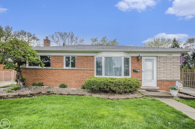 ranch-style home featuring brick siding, a front lawn, fence, and a chimney