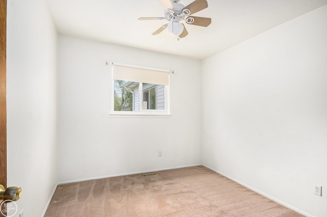 carpeted empty room featuring ceiling fan, visible vents, and baseboards