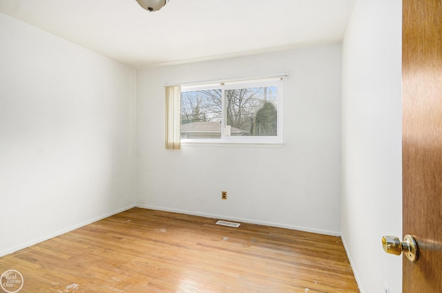 empty room with baseboards, light wood-style flooring, and visible vents