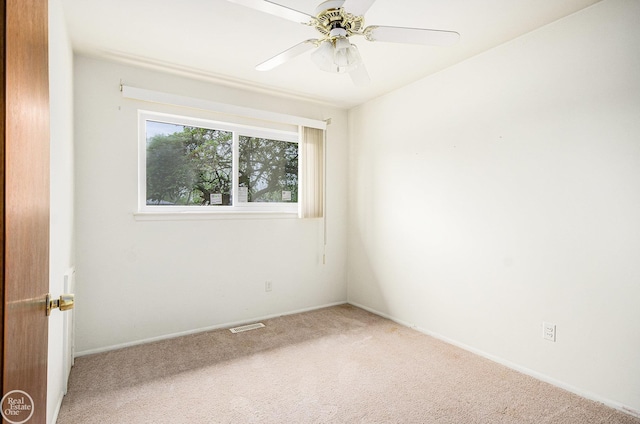 spare room featuring carpet flooring, ceiling fan, visible vents, and baseboards