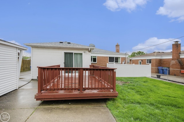 rear view of house featuring a lawn, fence, and a wooden deck
