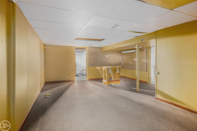 finished below grade area featuring baseboards, carpet flooring, and a drop ceiling