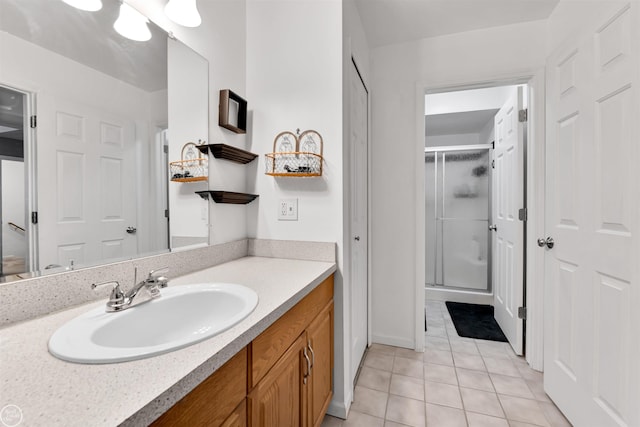 full bath featuring tile patterned flooring, vanity, and a shower stall