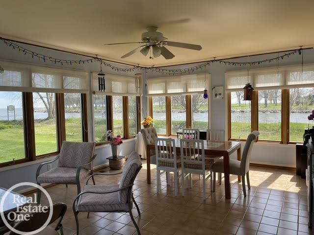 sunroom featuring baseboards, tile patterned floors, and a wealth of natural light