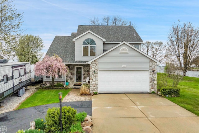 traditional home featuring roof with shingles, a front lawn, stone siding, a garage, and concrete driveway