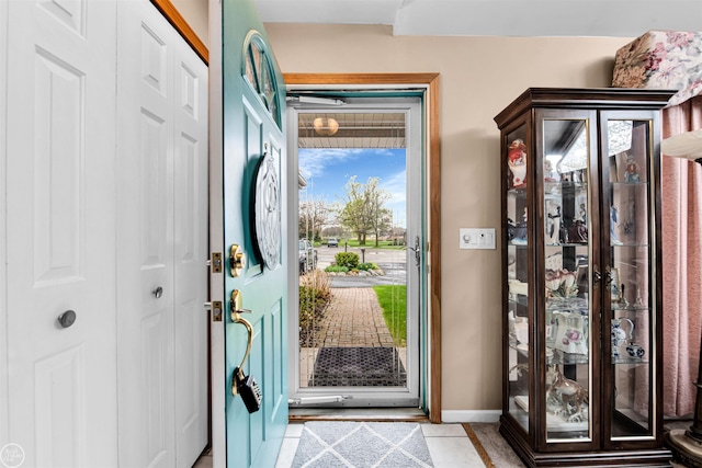 entryway featuring baseboards and light tile patterned floors