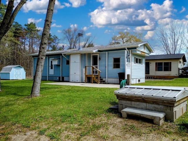 back of house with a storage shed, an outdoor structure, and a yard
