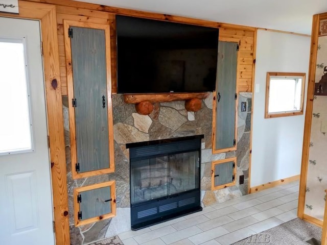living room with baseboards and a stone fireplace