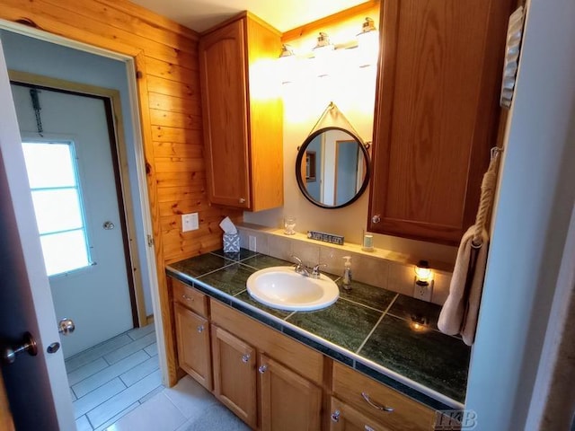 bathroom with vanity, wood walls, and tile patterned floors