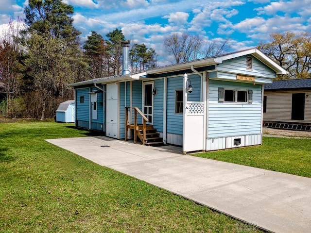 view of front of house with a shed, an outbuilding, and a front yard