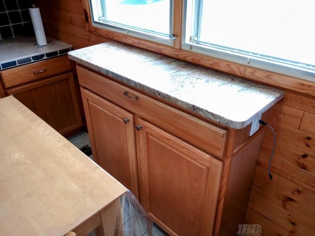 details featuring light countertops, tasteful backsplash, and brown cabinetry