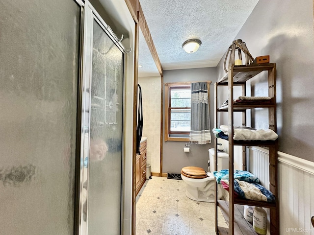 full bath with vanity, toilet, a textured ceiling, tile patterned floors, and a shower stall