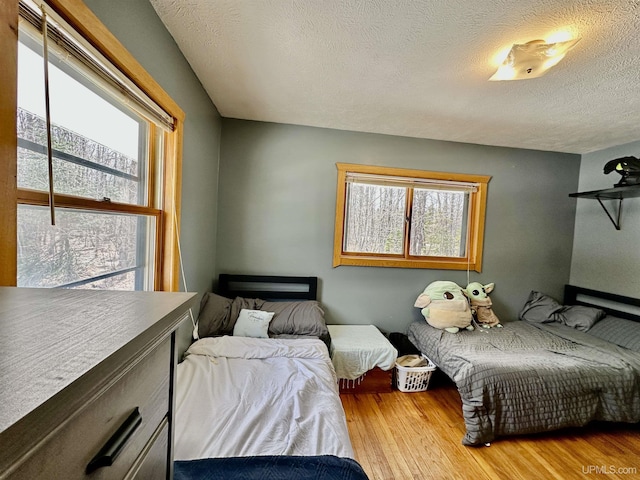 bedroom featuring a textured ceiling and wood finished floors