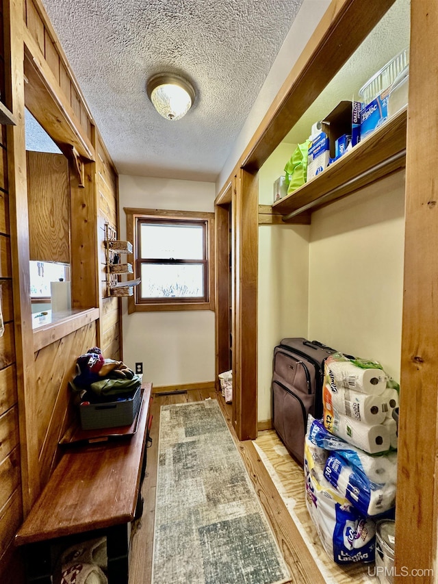 mudroom with a textured ceiling and wood finished floors