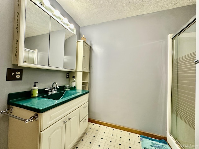 bathroom with vanity, a textured ceiling, tile patterned floors, and a shower stall