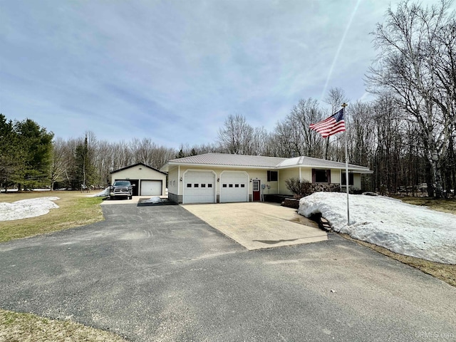 view of front of property with an attached garage, driveway, and metal roof