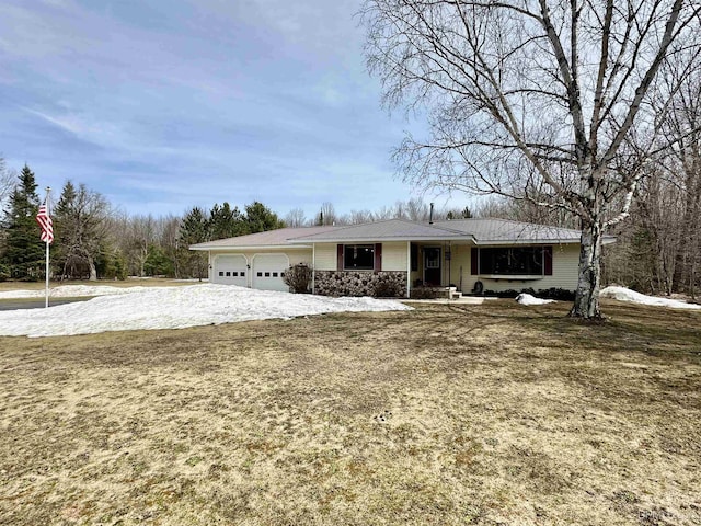 view of front of house featuring an attached garage, driveway, and metal roof
