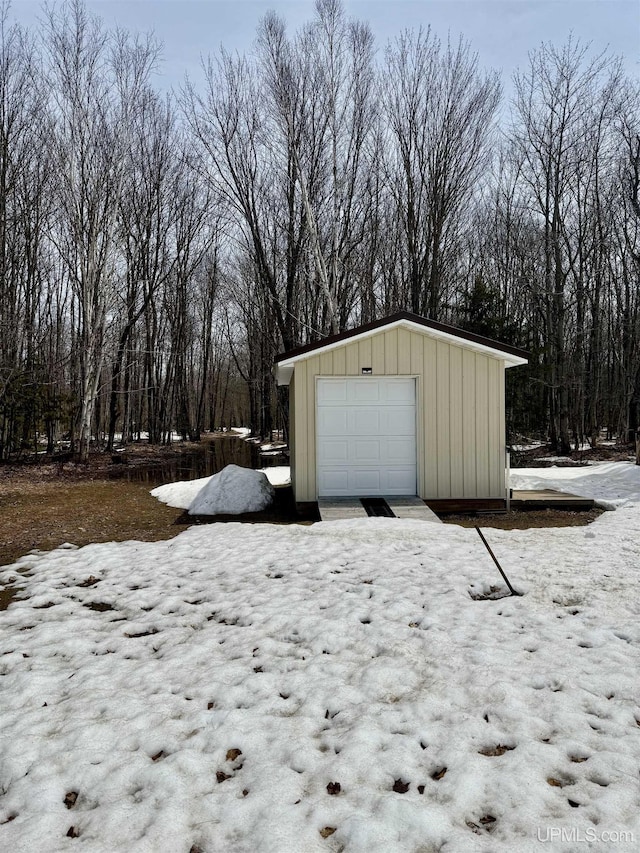 snow covered garage featuring a garage