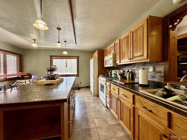 kitchen featuring white appliances, a center island, a textured ceiling, backsplash, and decorative light fixtures