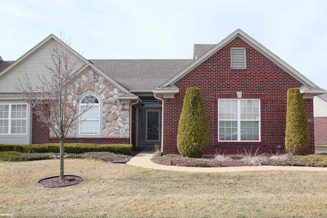 single story home with roof with shingles, a front lawn, and brick siding