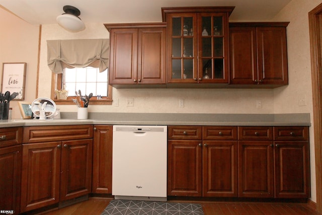 kitchen featuring light countertops, white dishwasher, dark wood-style floors, and glass insert cabinets