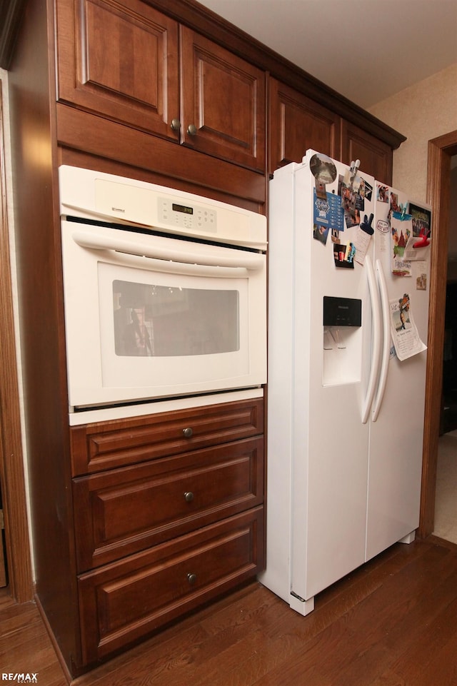 kitchen with dark wood finished floors and white appliances