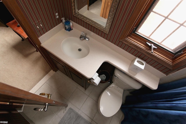 half bathroom featuring toilet, tile patterned floors, and vanity
