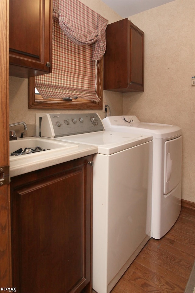 washroom featuring cabinet space, washing machine and dryer, and light wood-type flooring