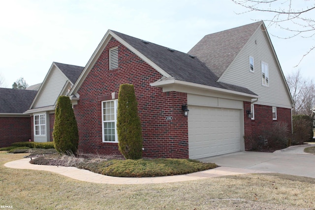 view of side of home with a garage, a shingled roof, driveway, and brick siding