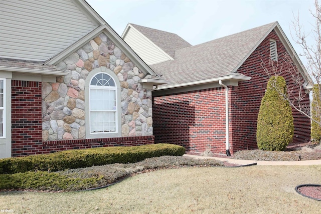 view of side of home featuring roof with shingles, brick siding, and stone siding