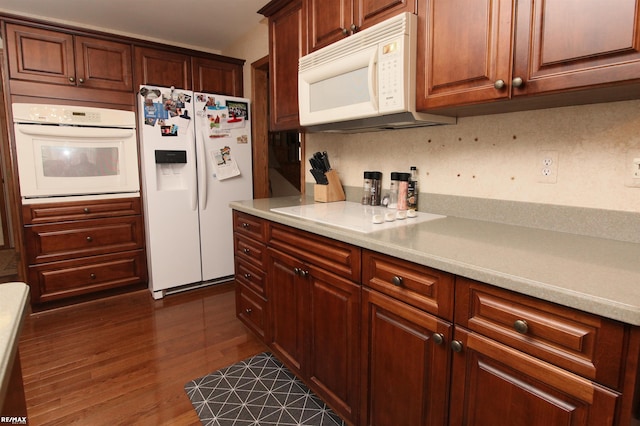 kitchen featuring white appliances, dark wood-style floors, and light countertops