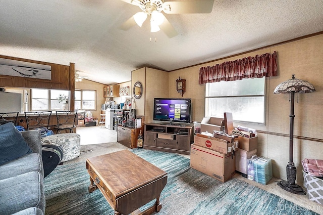 living room featuring ceiling fan, a textured ceiling, and lofted ceiling