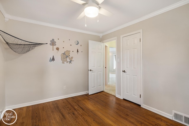 unfurnished bedroom with crown molding, baseboards, visible vents, and wood finished floors